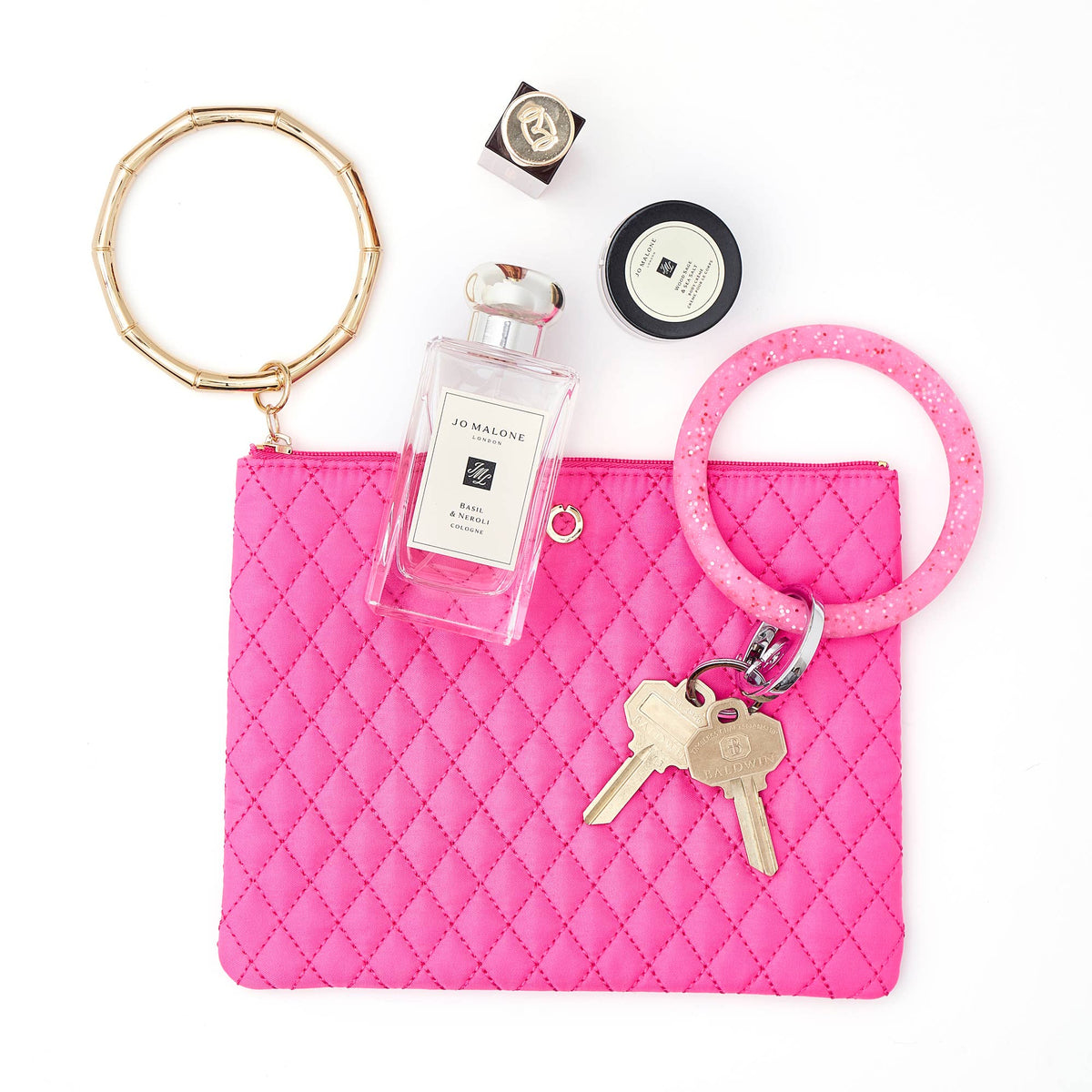 Tickled Pink Big O bracelet pouch styled with perfume, keys, and a coordinating key ring