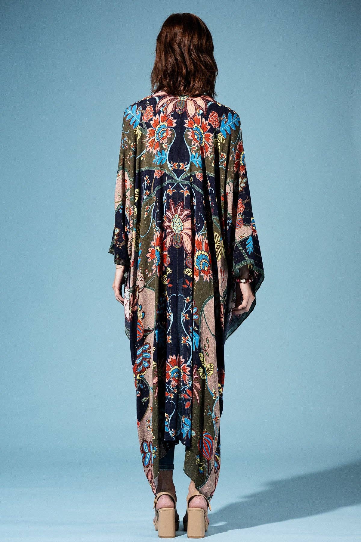 Woman wearing a colorful patterned dress against a blue background
