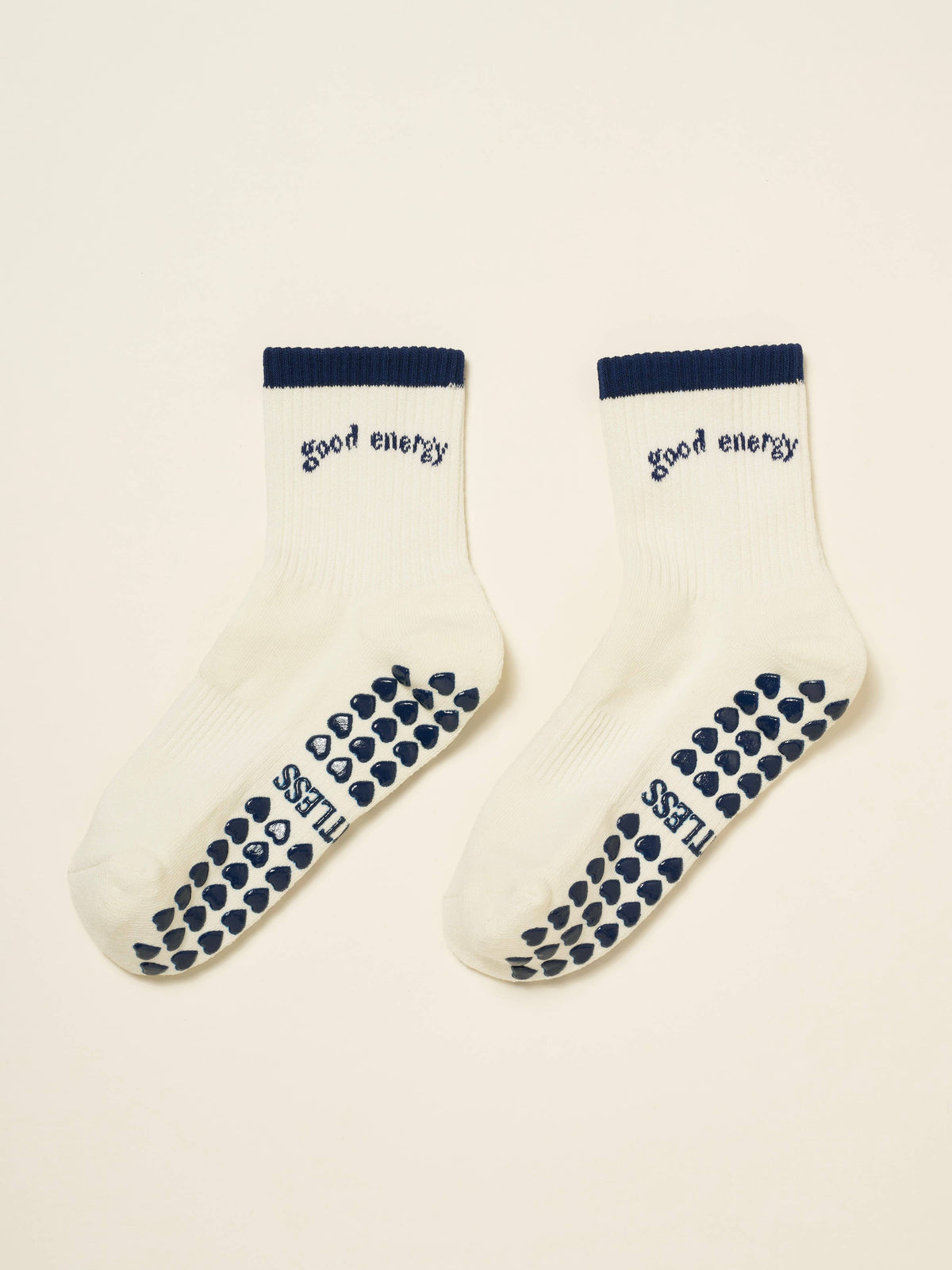 Pair of ivory Good Energy socks showing navy heart-shaped grip soles