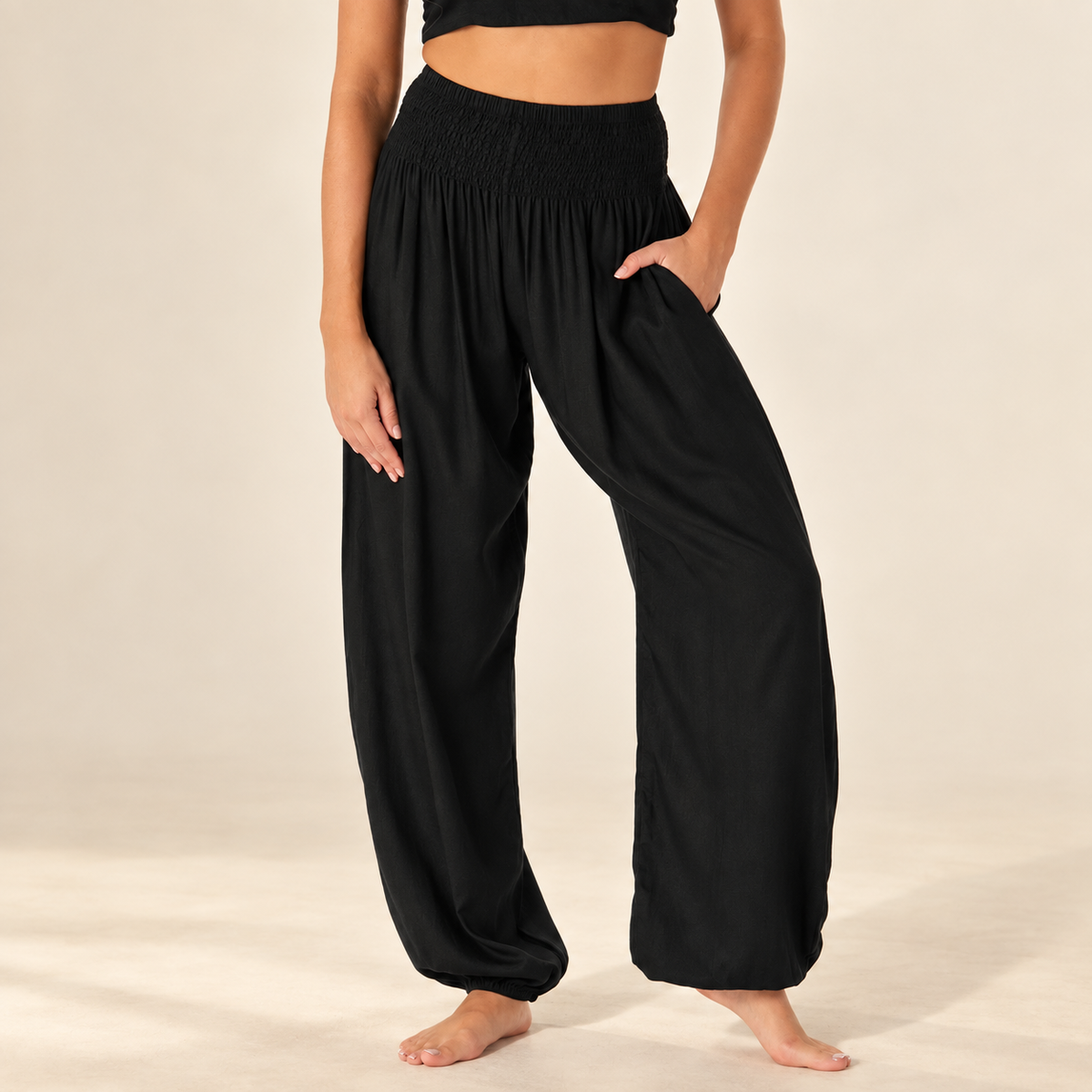 Black Harem Pants with Pockets showing the smocked waistband and relaxed leg on an ivory background