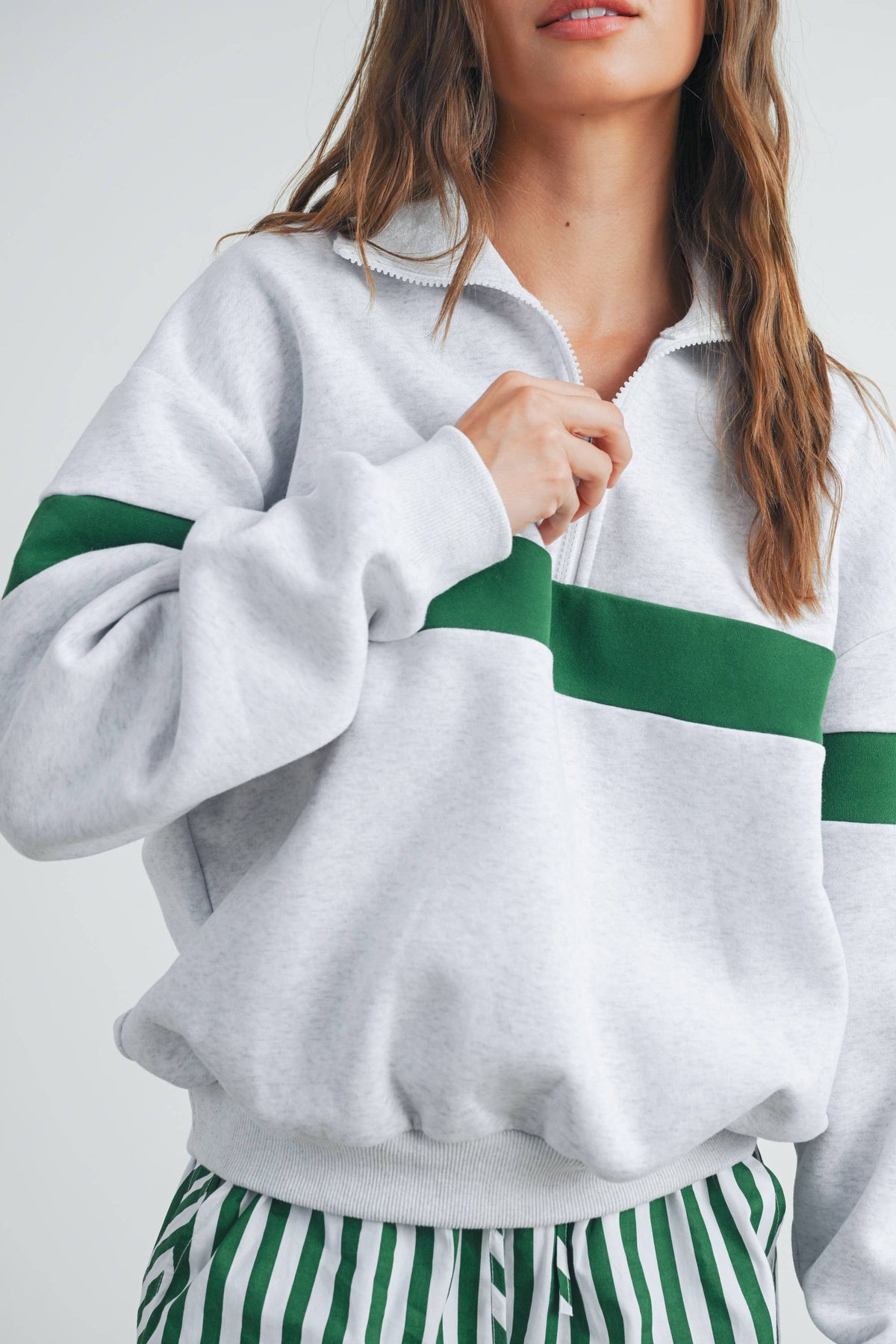 Close-up of half-zip collar and green stripe on grey sweatshirt