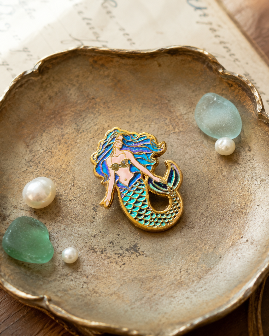 Colorful mermaid enamel pin styled with shells and sea glass