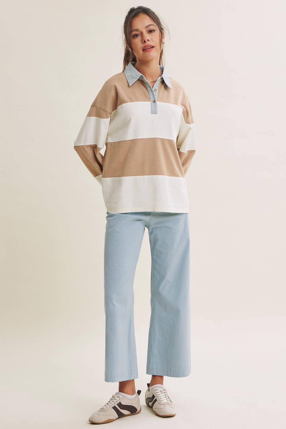 Full-length outfit with the oversized latte and cream rugby top, cropped jeans, and sneakers.