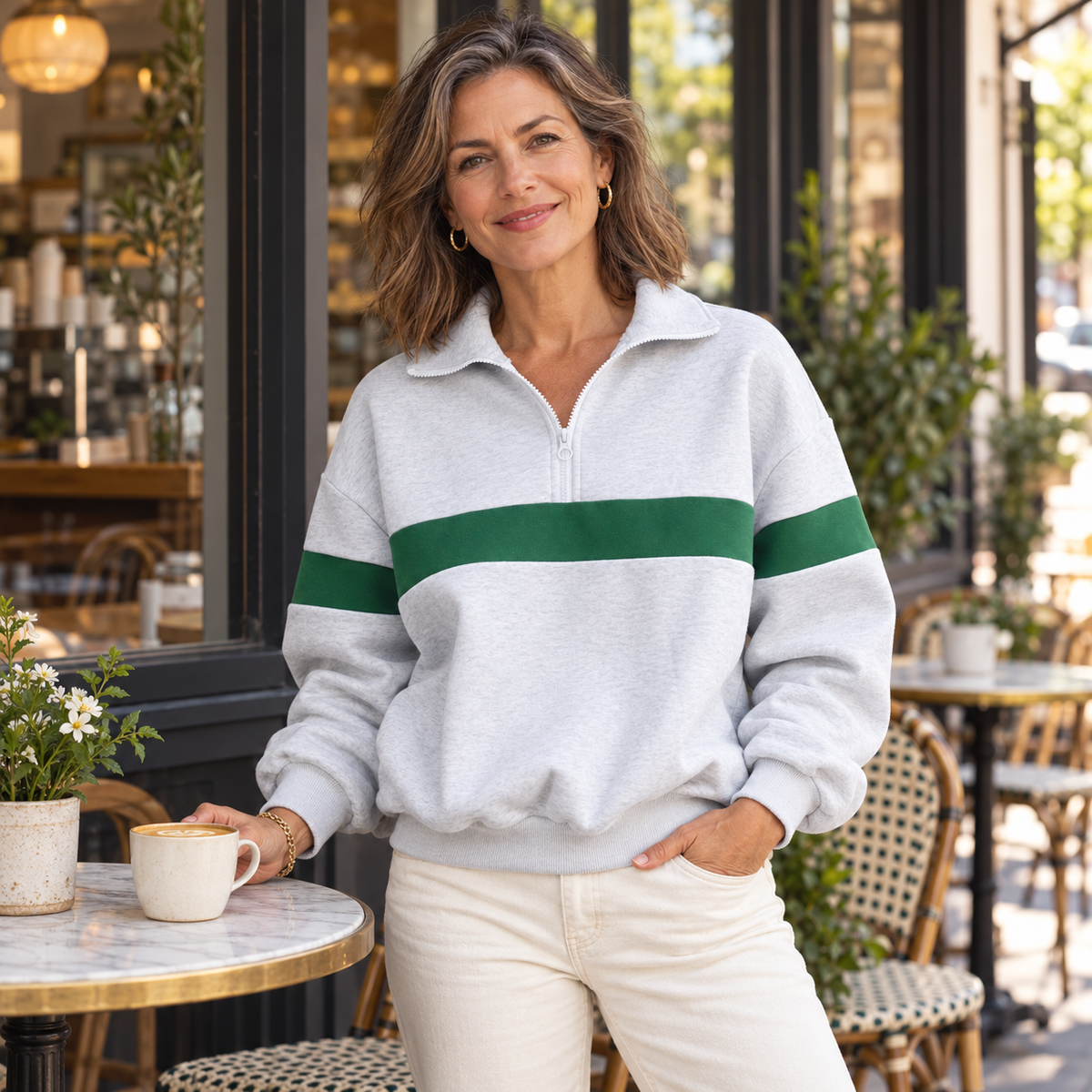House of Caelo grey and green half-zip sweatshirt on a mature woman at a neighborhood coffee shop