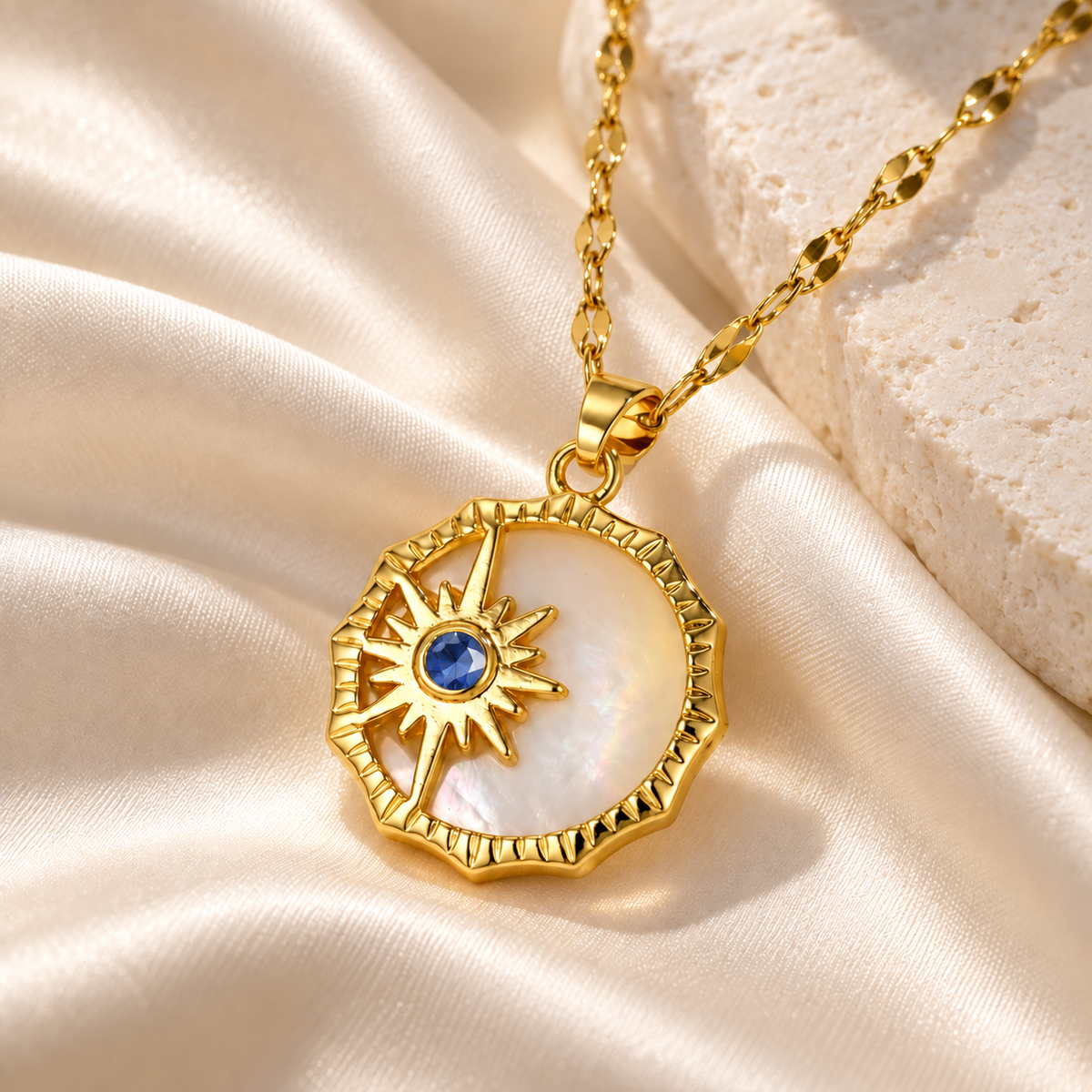 Sol & Luna mother-of-pearl necklace with a faceted sapphire-colored crystal and gold sunburst detailing on ivory silk | House of Caelo
