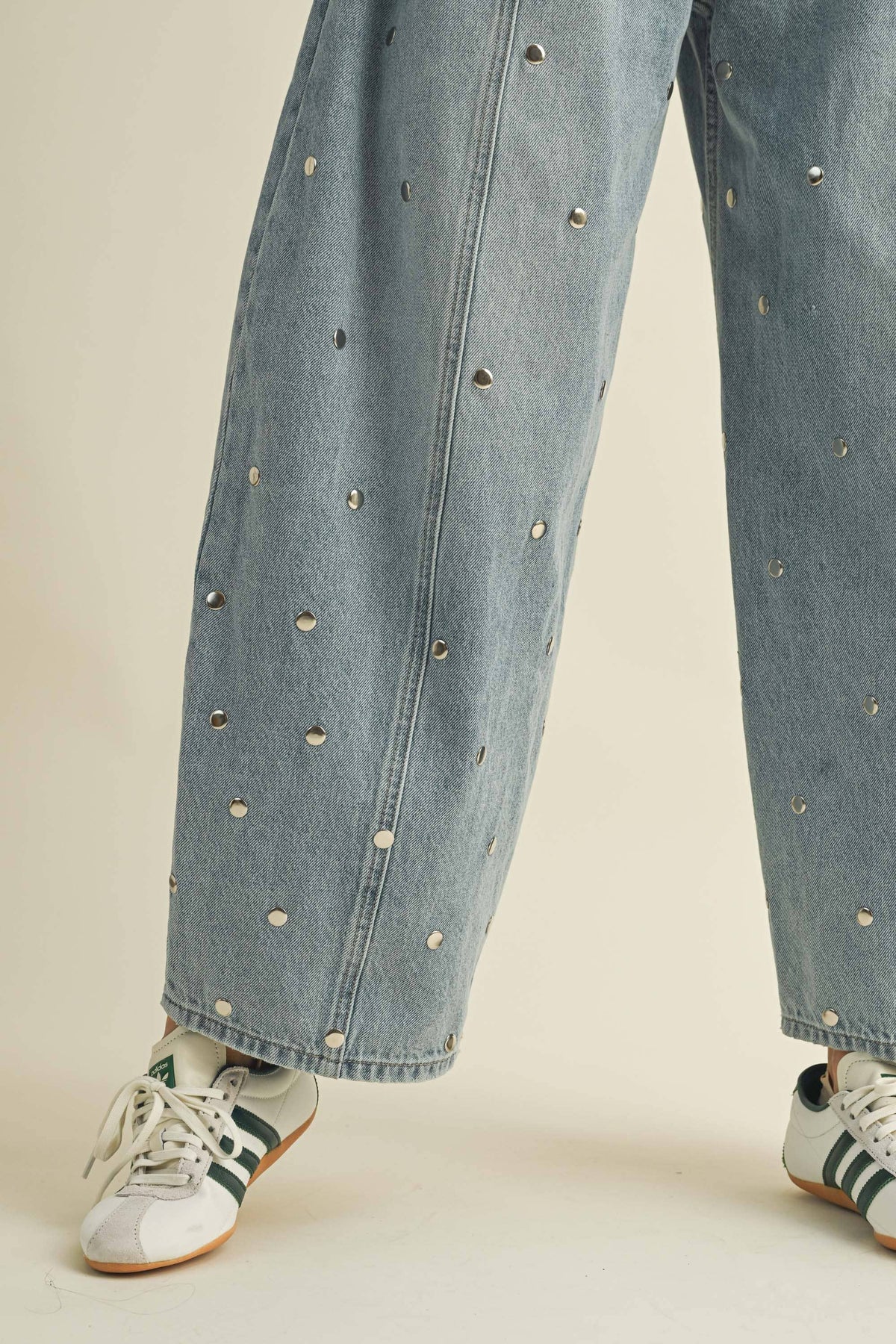 Full-length styling view of women’s studded barrel jeans in a light denim wash