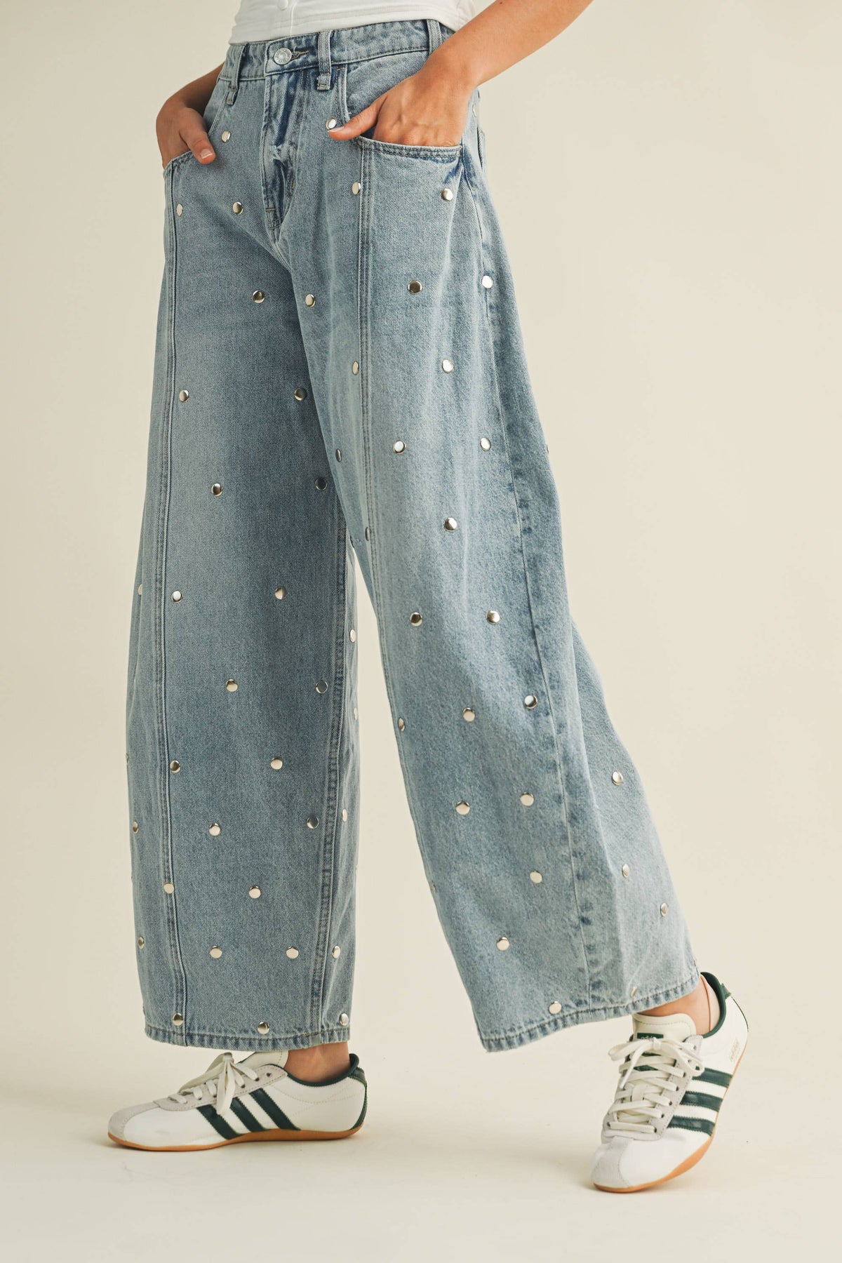 Women’s light-wash studded barrel jeans shown from the side with tapered ankle shape
