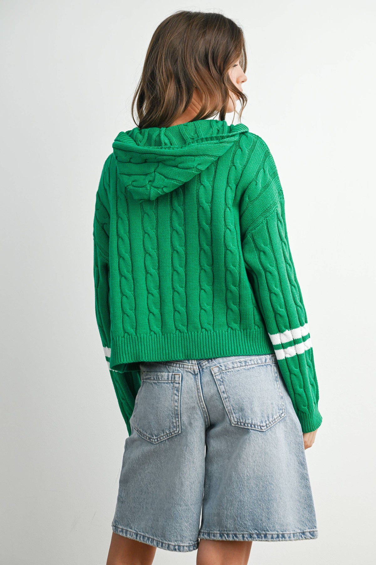 Green cable-knit zip-up hoodie cardigan with ivory sleeve stripes, back view showing hood