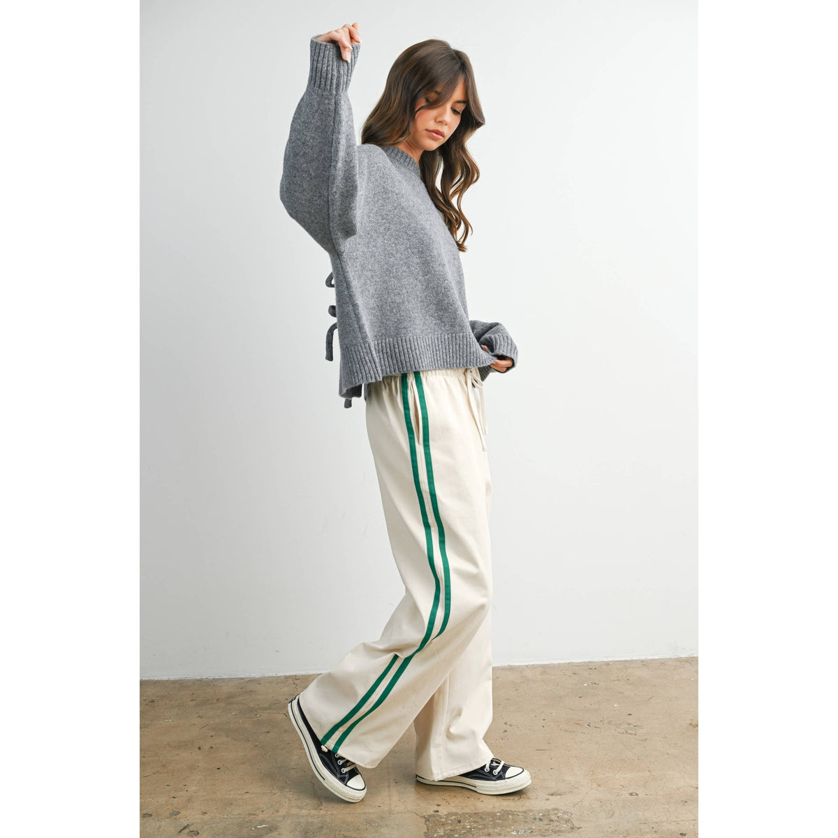 Ivory wide-leg drawstring track pants with green side stripes, side outfit view