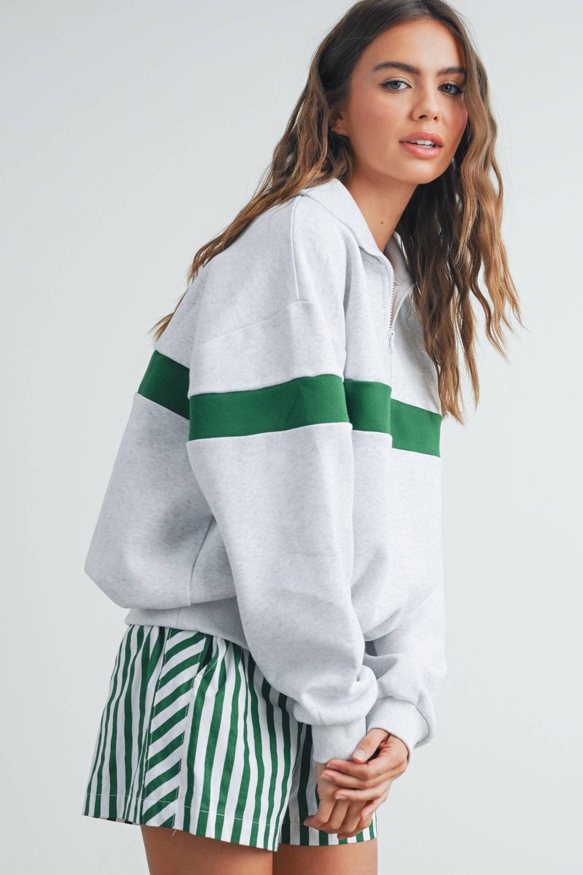 Side view of grey and green collared sweatshirt