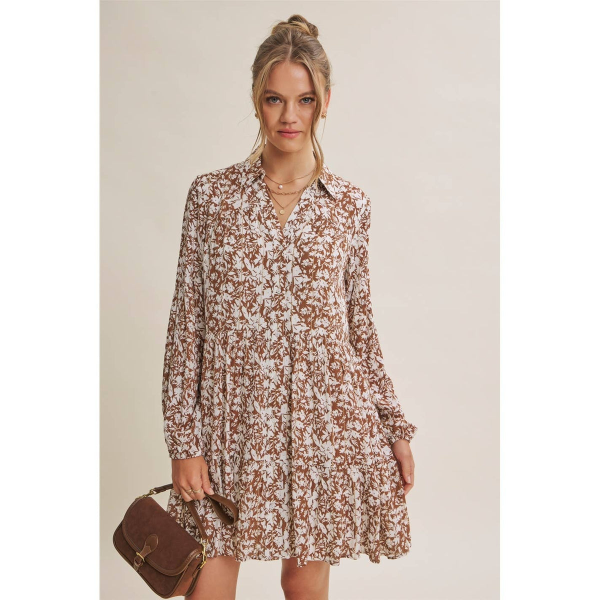 Mocha and cream floral mini dress showing the button-down front and loose hem.