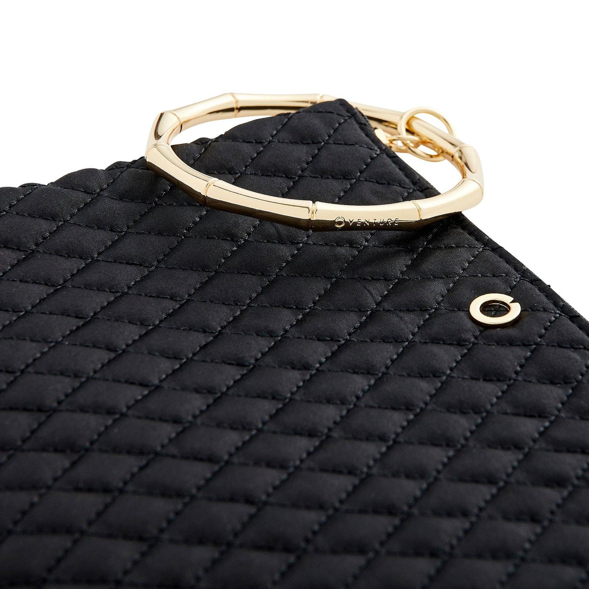 Close-up of black diamond quilting and the segmented gold bracelet handle