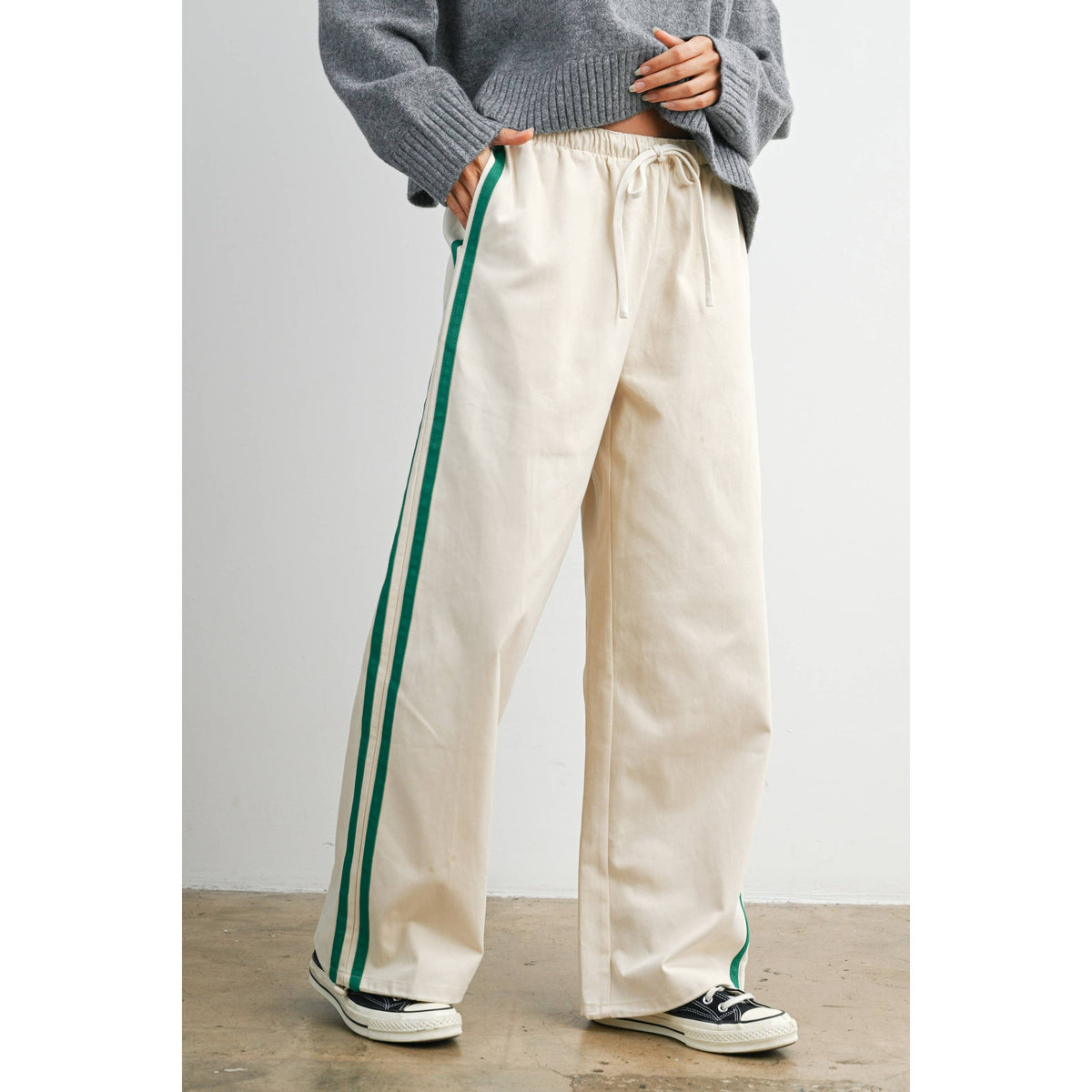 Ivory wide-leg drawstring track pants with green side stripes, front view