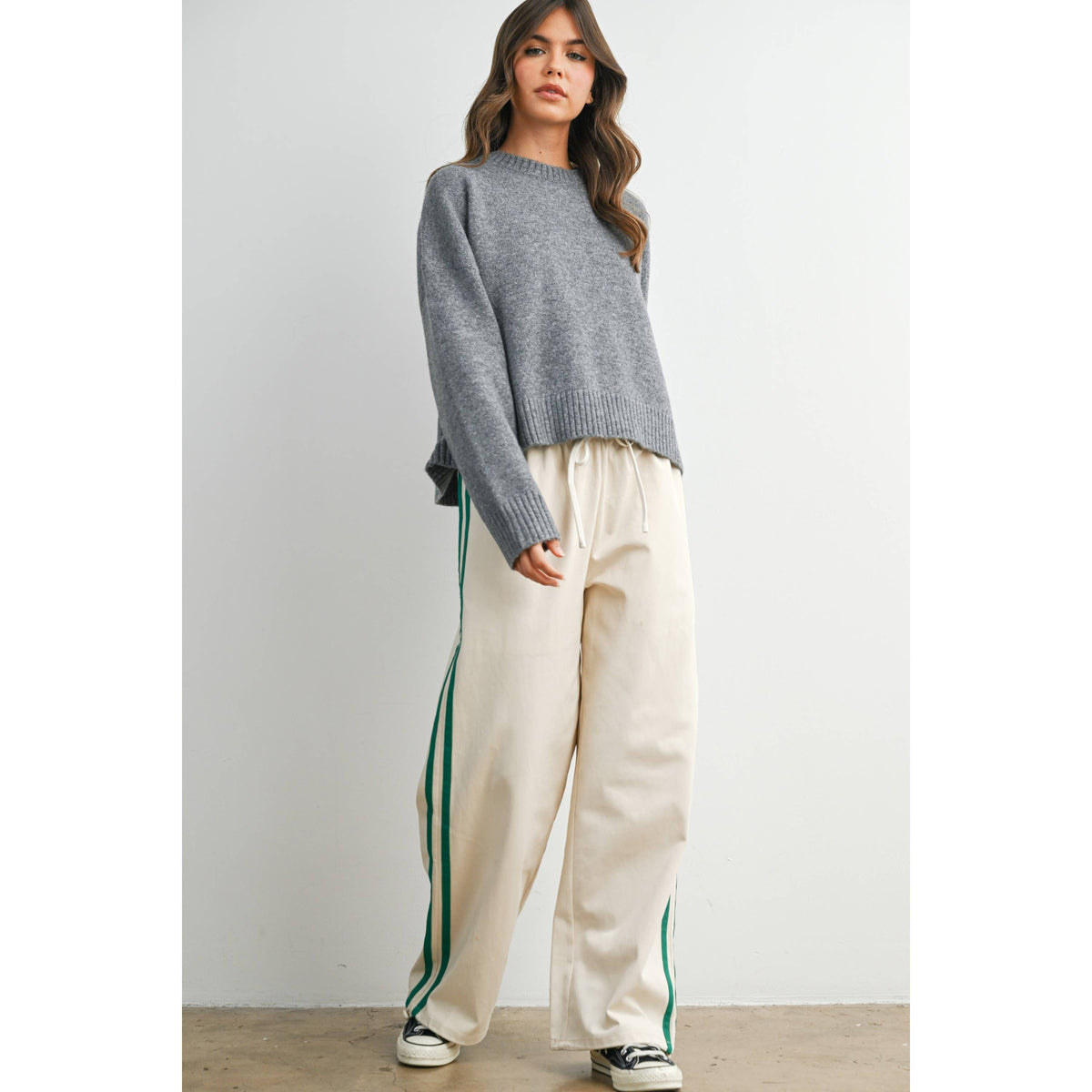 Ivory wide-leg drawstring track pants with green side stripes, full outfit view