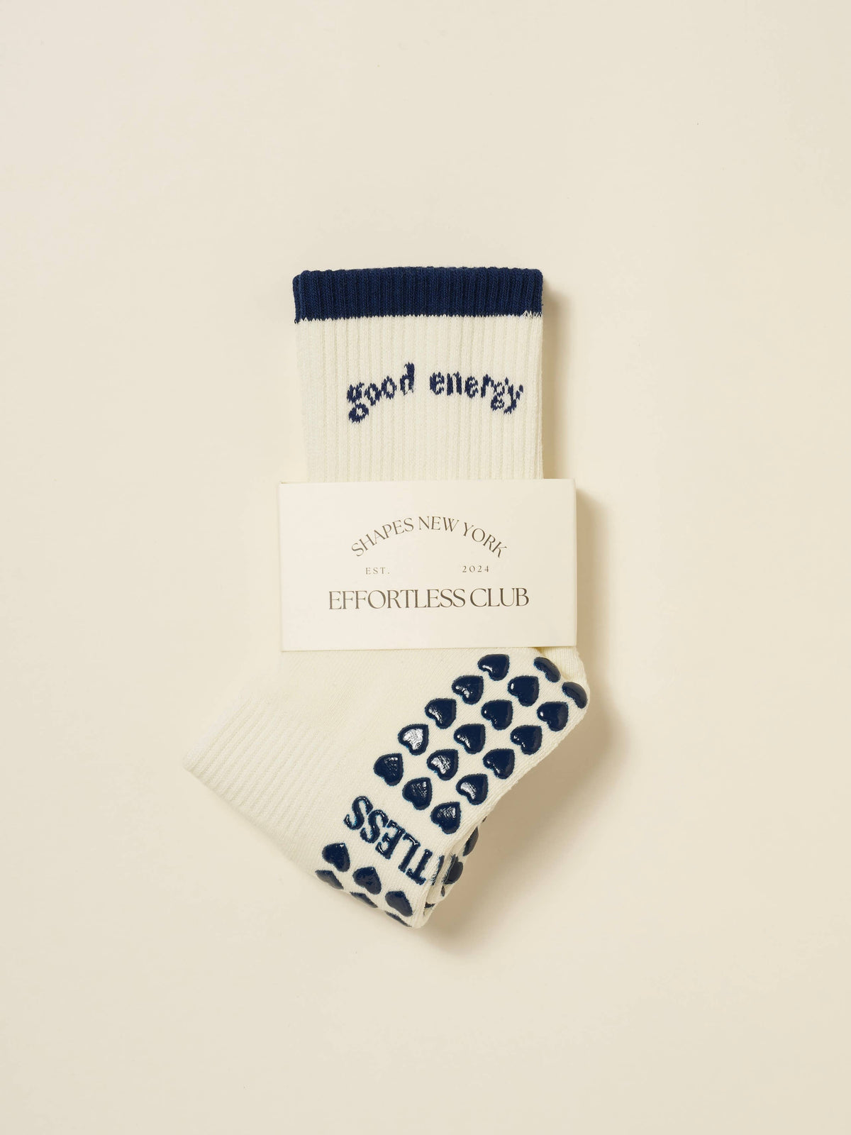 Packaged ivory Good Energy grip socks with navy heart-shaped sole grips