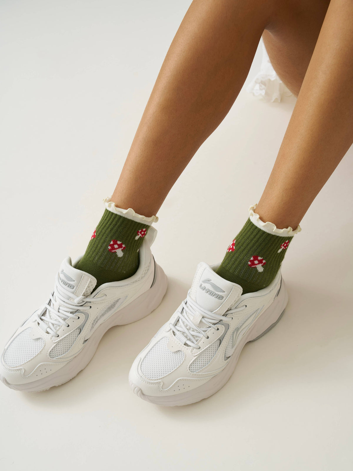 Olive mushroom ruffle grip socks styled with white sneakers