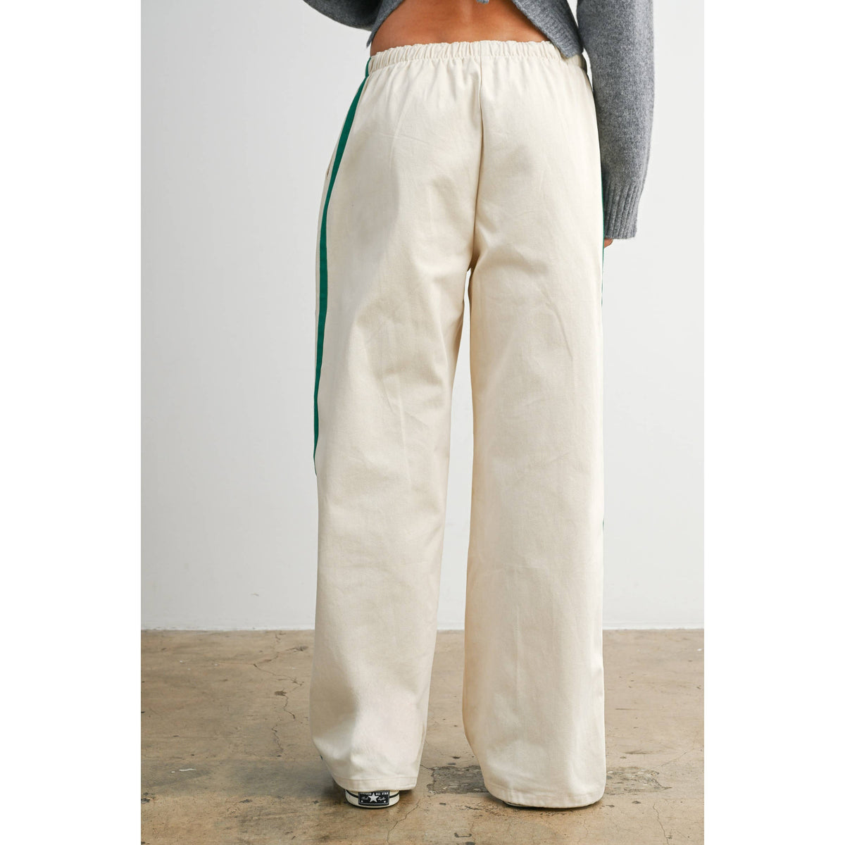 Ivory wide-leg drawstring track pants with green side stripes, back view