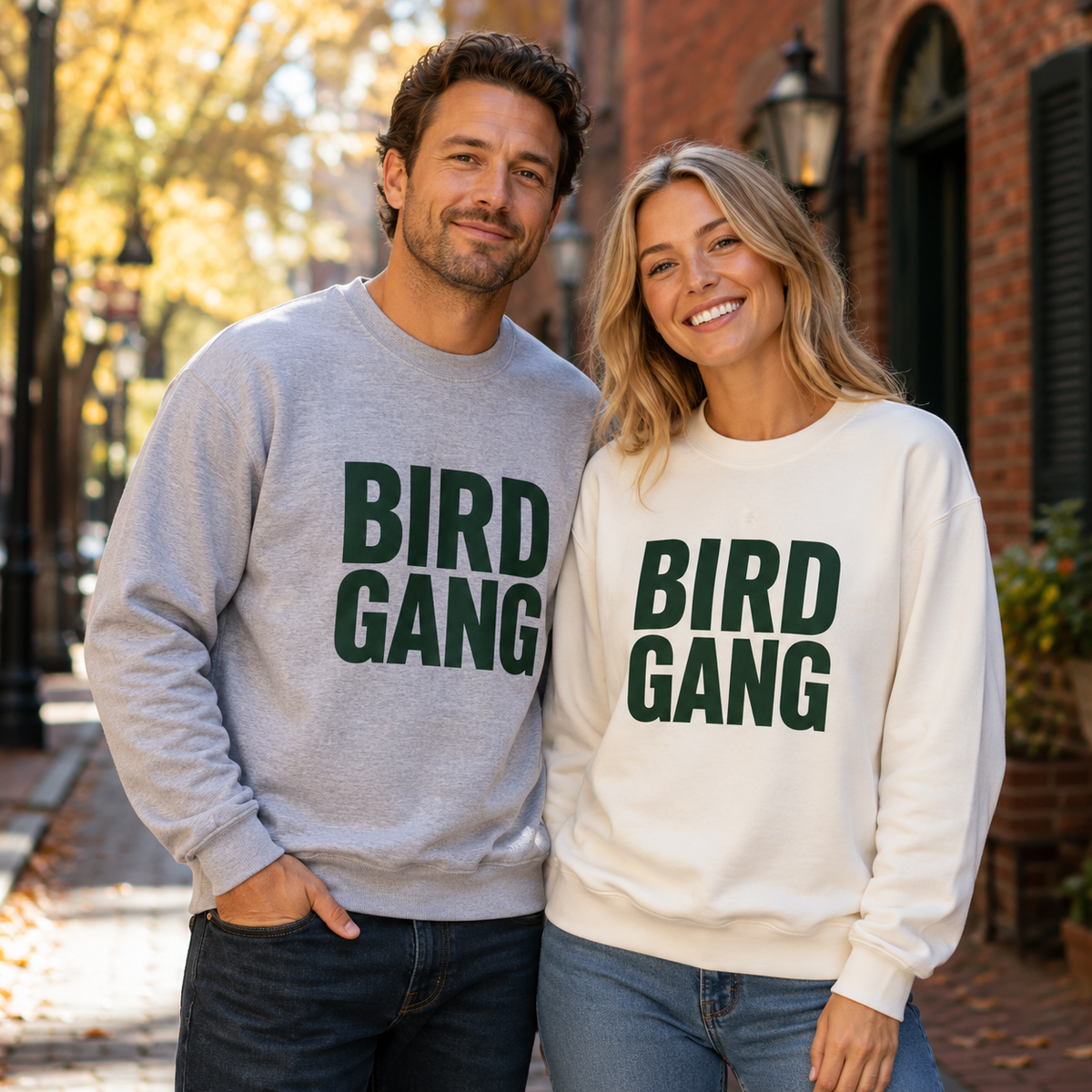 Man in Sport Grey and woman in White BIRD GANG unisex crewneck sweatshirts in a Philadelphia fall setting
