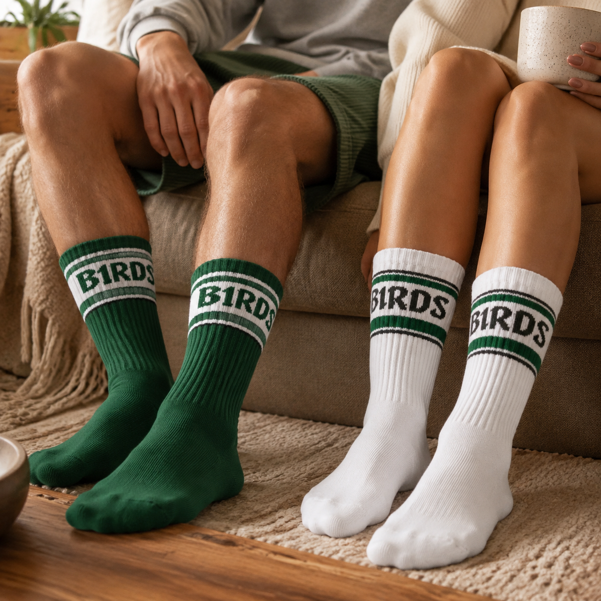 Two people wearing the green and white B1RDS ribbed game-day sock colorways in a cozy living room.