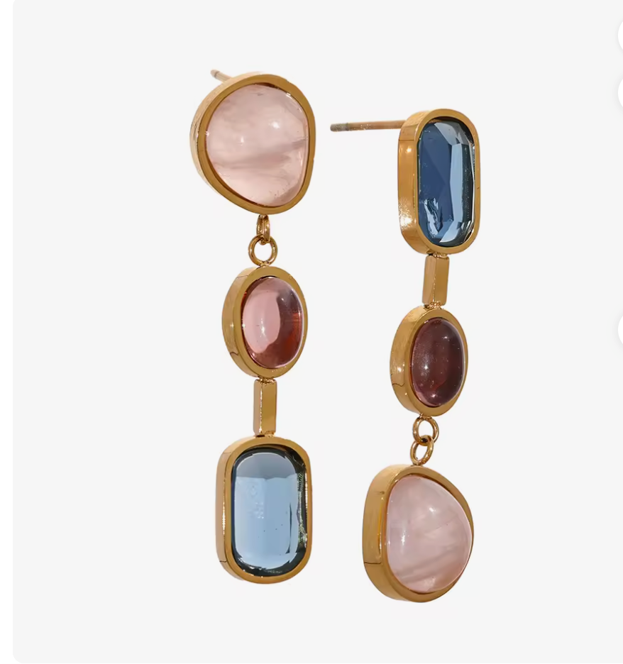 Close-up of gold tone Celestial Stone Geometric Drop Earrings with pink red and blue stones