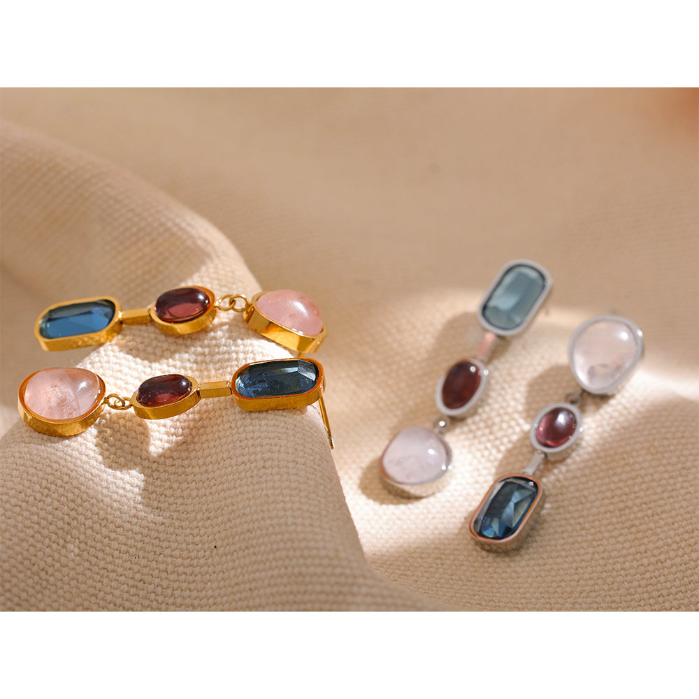 Gold and silver tone Celestial Stone Geometric Drop Earrings styled on cream fabric