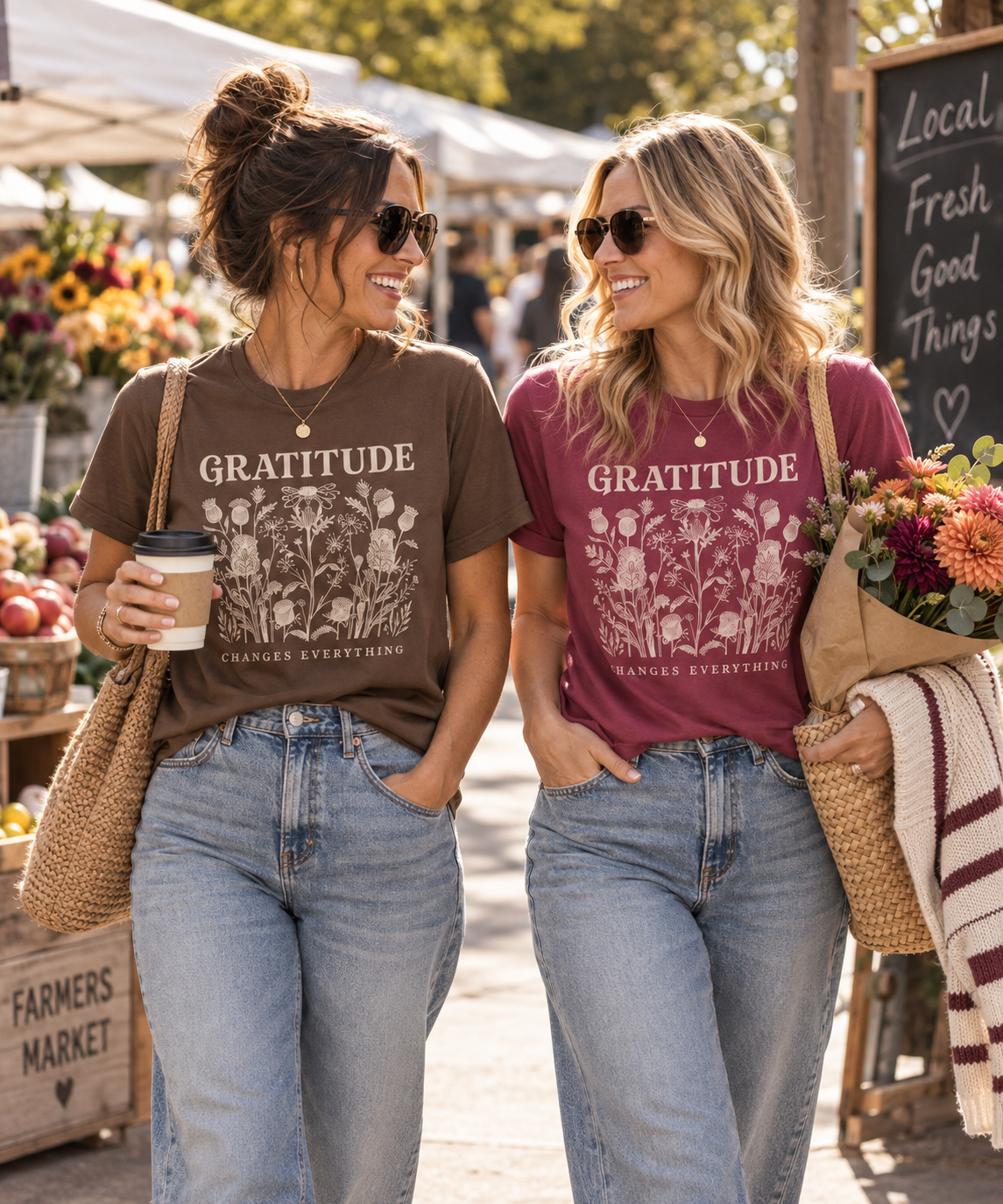 Two women wearing House of Caelo Gratitude Changes Everything tees in Espresso and Berry at a farmers market