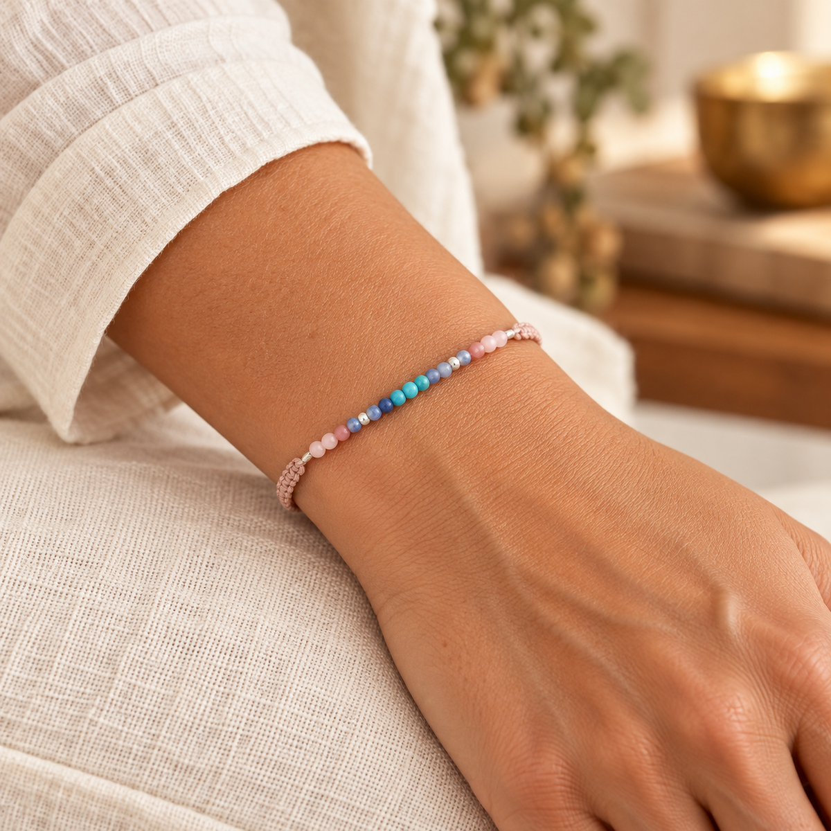 Woman wearing the delicate Om Namaste pink cord and multicolor stone bracelet