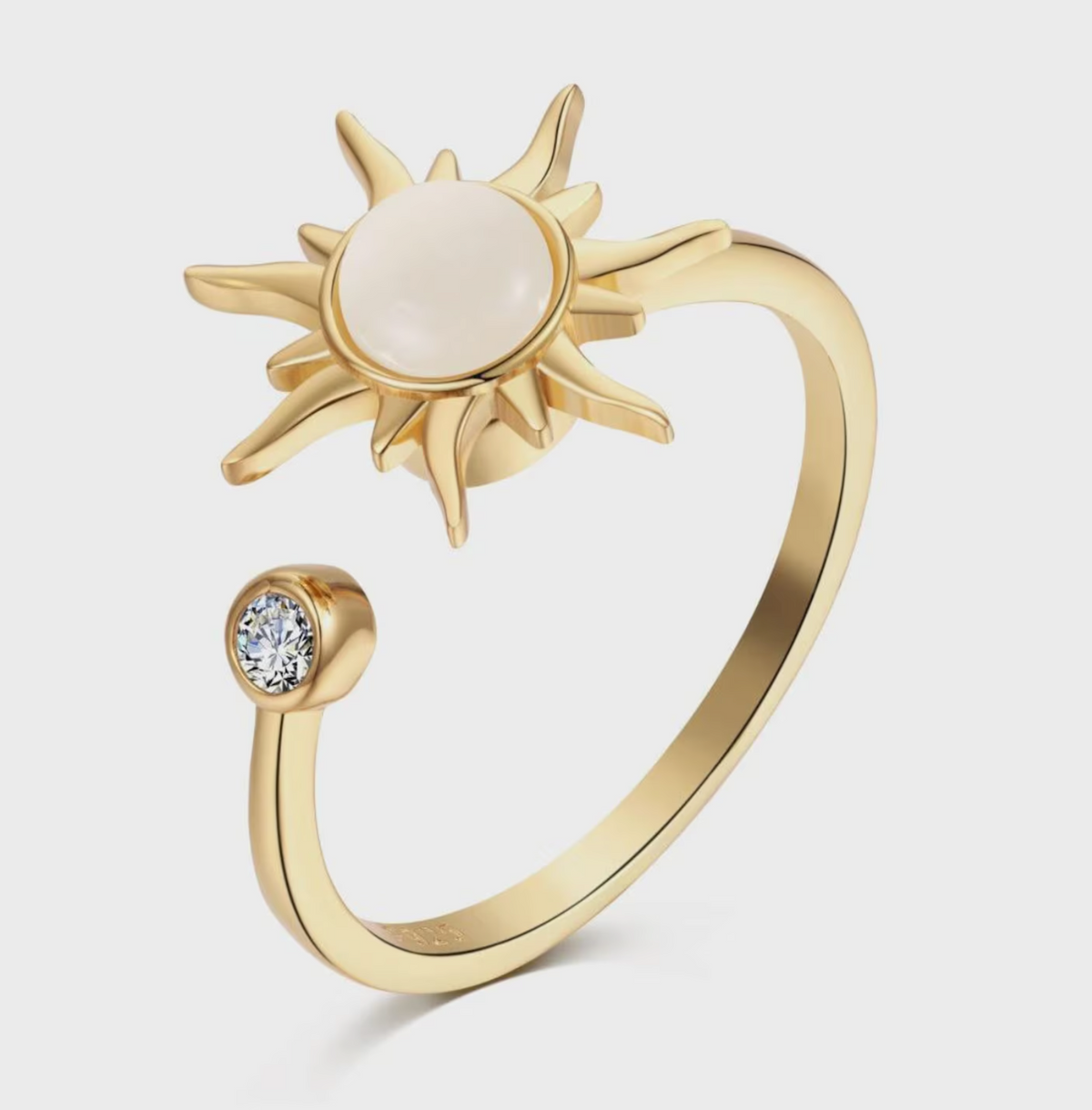 Gold Solstice Spinner Ring with pearl-look sun center and crystal accent
