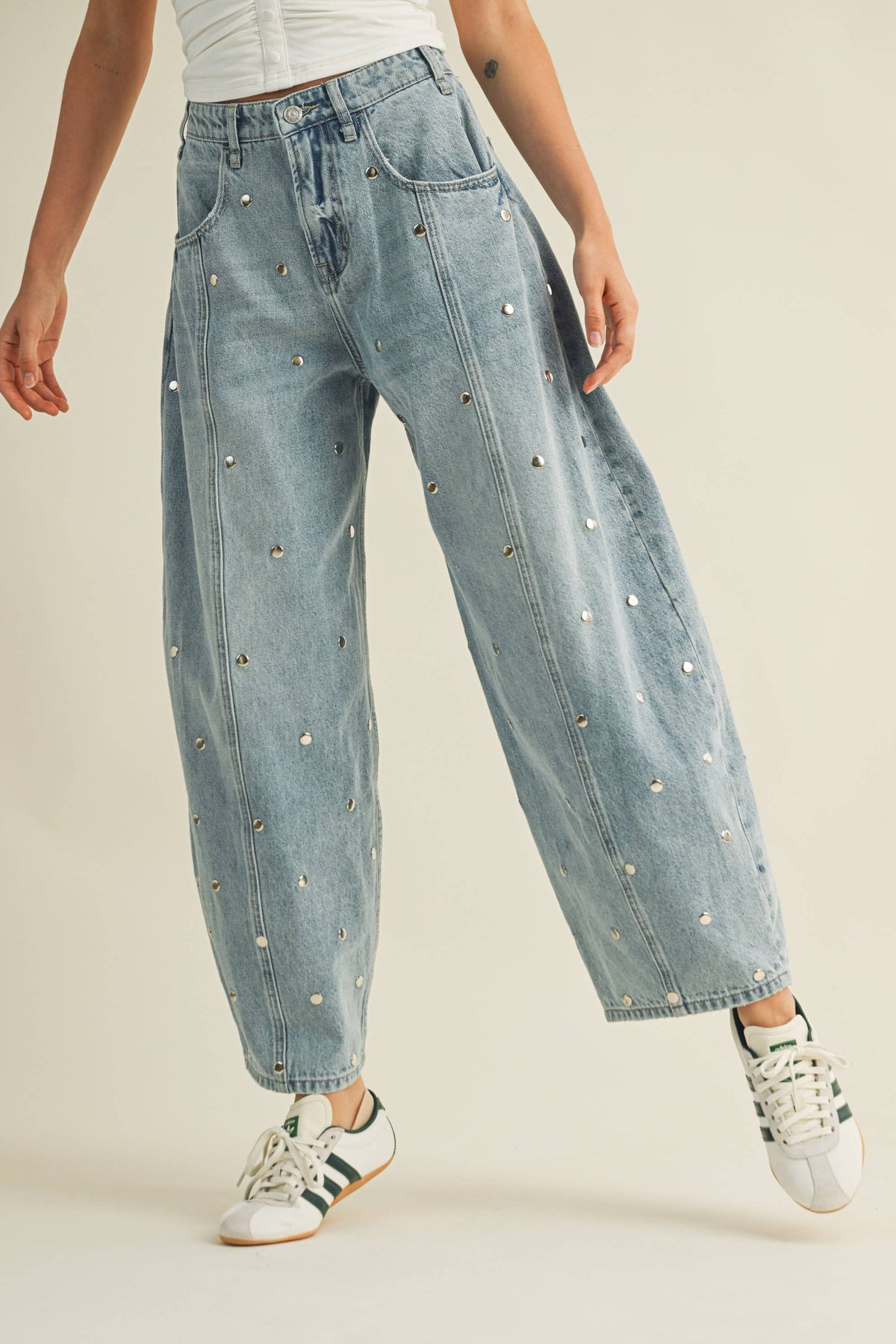 Light-wash barrel leg jeans with stud detailing styled casually with sneakers